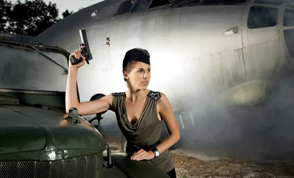 Jovem soldado feminino atraente com o avião e carro — Fotografia de Stock