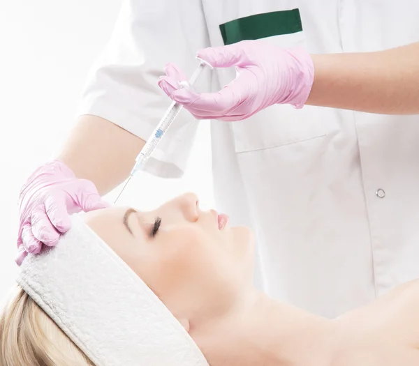 Mooie vrouw krijgt een injectie in haar gezicht — Stockfoto