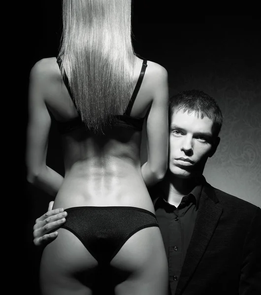 Лицо молодого жестокого мужчины, смотрящего с женской спины — стоковое фото