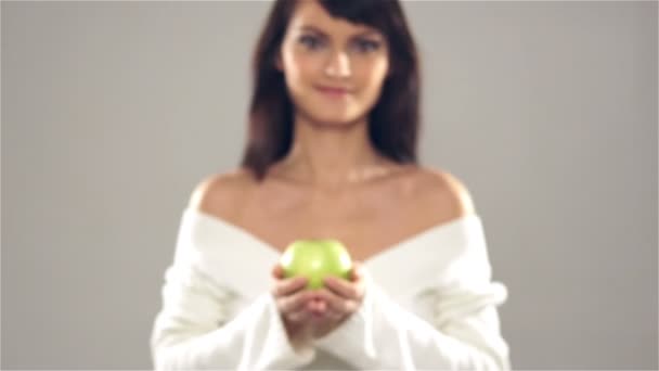 Una mujer joven y feliz compartiendo una manzana verde fresca — Vídeos de Stock