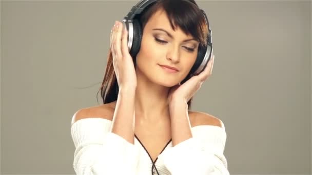 A young woman listening to the music in headphones — Stock Video