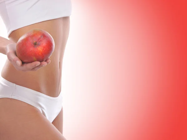 Diätkonzept, schöner Bauch und eine auf Rot isolierte Frucht — Stockfoto