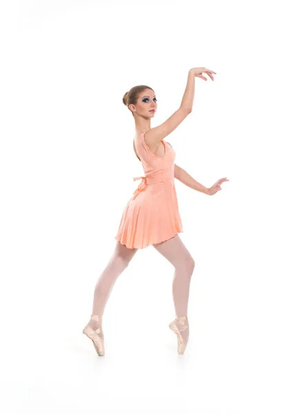 Eine junge Balletttänzerin in einem hellen Kleid auf weißem Hintergrund — Stockfoto