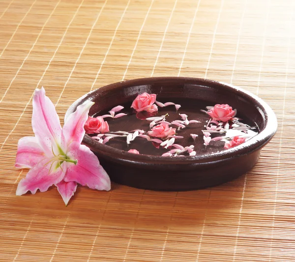 Taça de cerâmica com algumas flores e pétalas — Fotografia de Stock