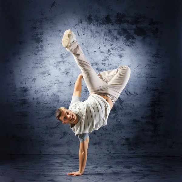 En ung och vältränad dansare i moderna kläder utför — Stockfoto