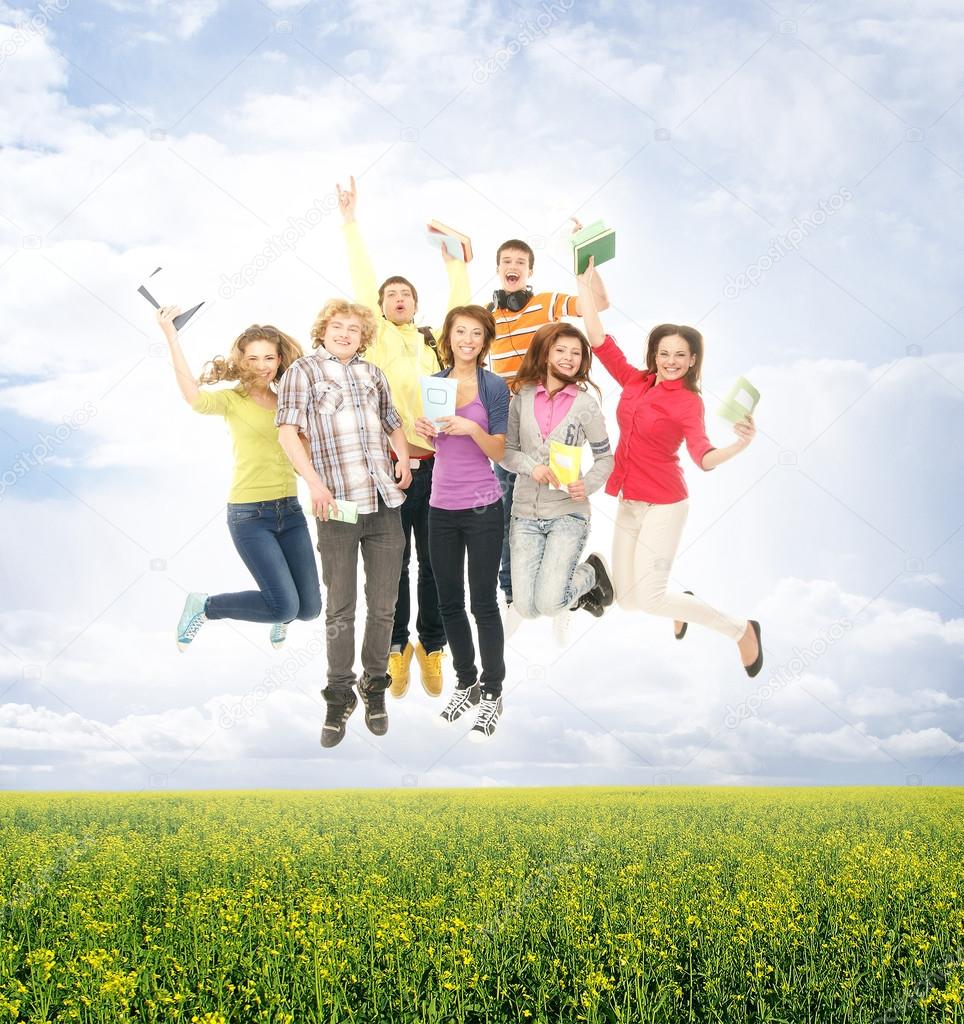 Group of smiling teenagers staying together and looking at camer