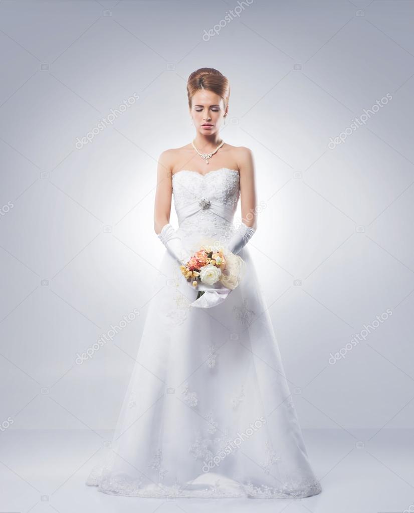 Young and beautiful bride standing with the flower bouquet