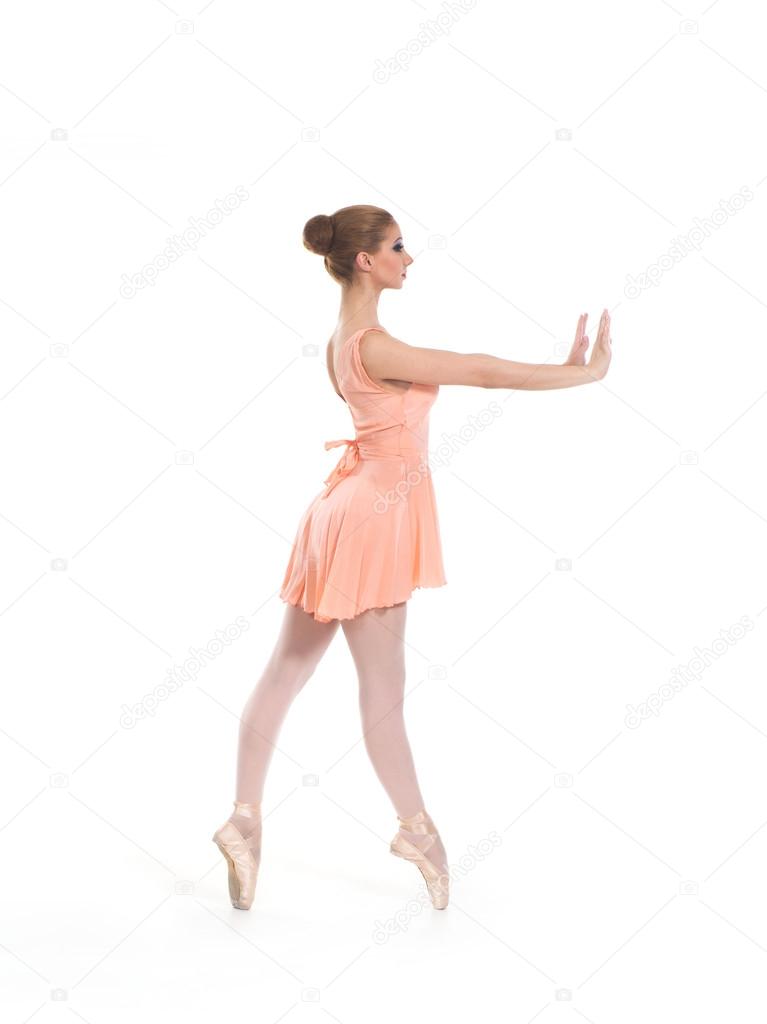 A young ballet dancer in a light dress on a white background