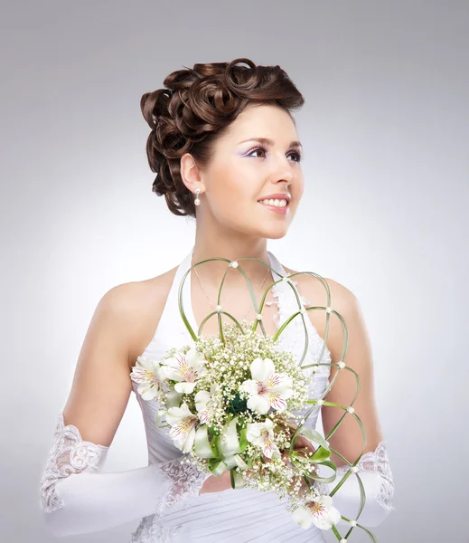 Молодая, красивая и эмоциональная невеста с красивыми цветами — стоковое фото