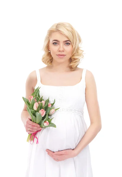 Een jonge blonde zwangere vrouw met een boeket van bloemen — Stockfoto