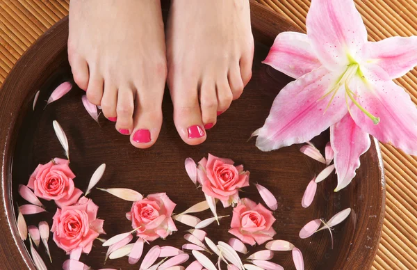 美丽的双腿，鲜花、 花瓣和陶瓷碗 spa 背景 — 图库照片