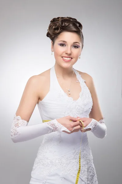 Young and beautiful bride measures her waist — Stock Photo, Image