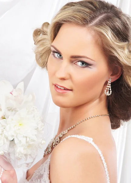 Junge, schöne und emotionale Braut mit wunderschönen Blumen — Stockfoto