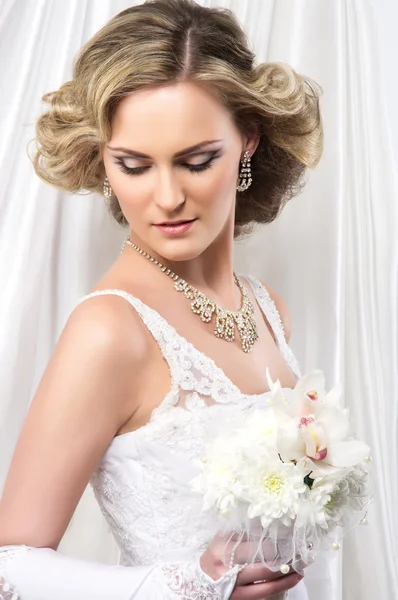 Jeune et belle mariée debout avec le bouquet de fleurs sur — Photo