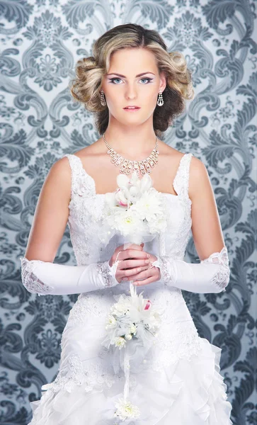 Young, beautiful and emotional bride with a beautiful flowers — Stock Photo, Image