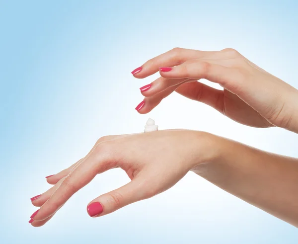 Красиві жіночі руки з кремом ізольовані на білому — стокове фото