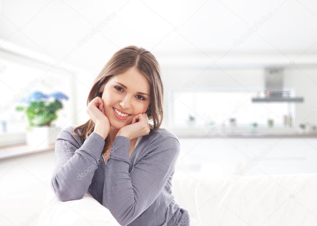 Young attractive girl sitting and relaxing on the sofa
