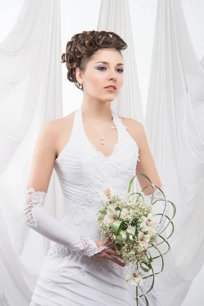 Noiva jovem e bonita de pé com o buquê de flores — Fotografia de Stock