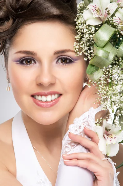 Young and beautiful bride standing with the flower bouquet over — Stock Photo, Image