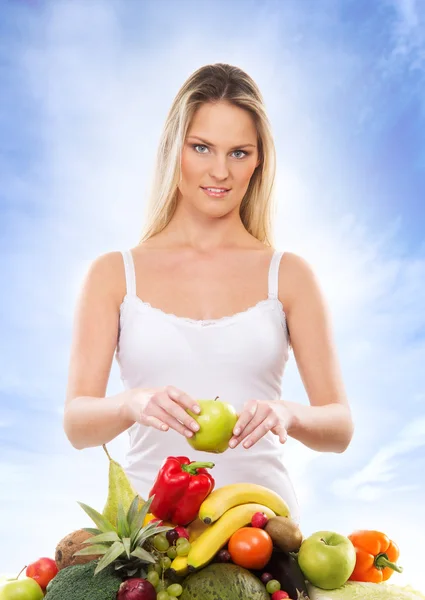 Jeune fille attrayante avec une pile de fruits et légumes isola — Photo