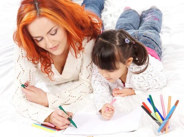 Een gelukkige moeder en een jonge dochter bent op een lichte achtergrond — Stockfoto