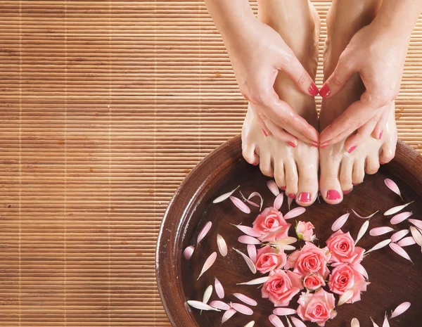 Fundo de spa com umas belas pernas, flores, pétalas e cerami — Fotografia de Stock