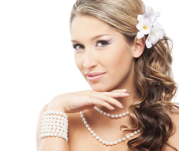 真珠の宝石類と彼女の髪に花を持つ若い、魅力的な女性 — ストック写真