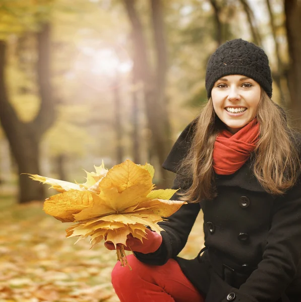 Krásná a šťastná mladá žena s kyticí podzimní listí — Stock fotografie