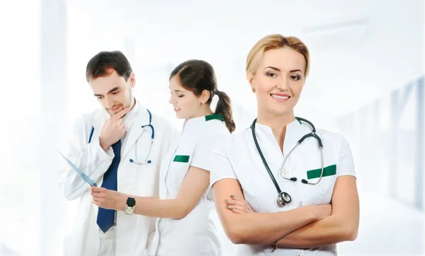 Team junger und intelligenter Mediziner über abstrakten Krankenhaushintergrund — Stockfoto