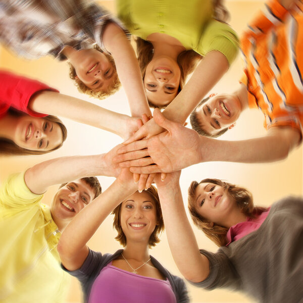 Team of smiling teens staying together and looking at camera