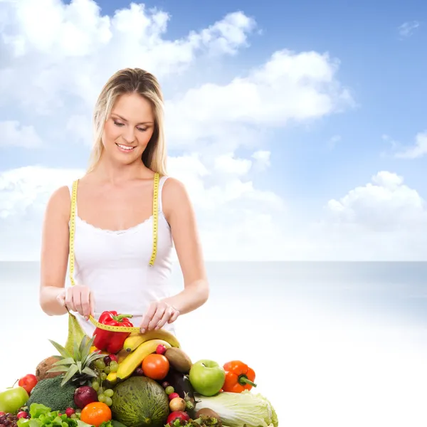 Meisje met een stapel van groenten en fruit — Stockfoto