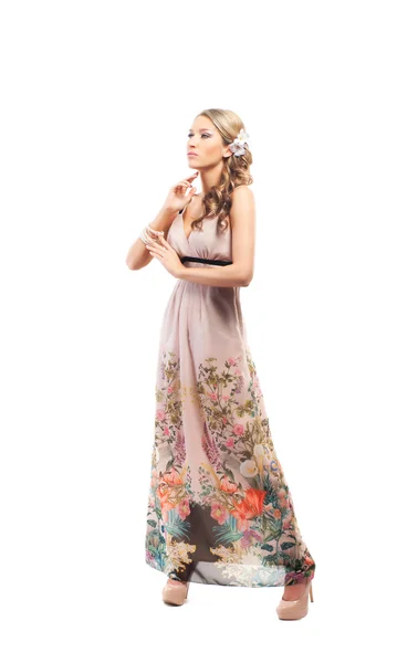 Een jonge blonde vrouw poseren in een lange jurk met shopping tassen — Stockfoto