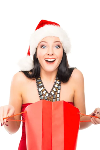 Una mujer feliz en un sombrero de Navidad sosteniendo una bolsa de compras roja — Foto de Stock