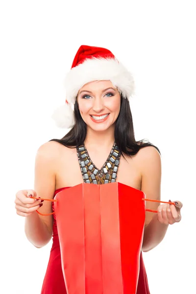 Una mujer feliz en un sombrero de Navidad sosteniendo una bolsa de compras roja — Foto de Stock