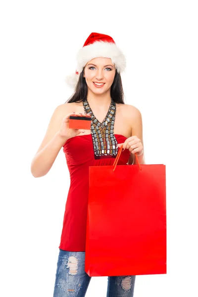 Uma mulher feliz em um chapéu de Natal segurando um saco de compras vermelho — Fotografia de Stock