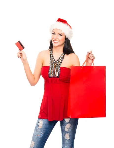 En glad kvinna i en jul hatt håller en röd shopping väska — Stockfoto