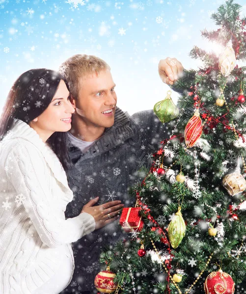 A pregnant woman and a happy man posing near the Christmas tree — Stock Photo, Image