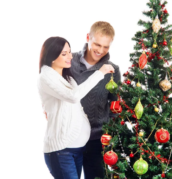 Hamile bir kadın ve mutlu bir adam Noel ağacının yanında poz — Stok fotoğraf