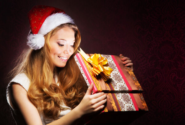 Young teenage girl opening the present