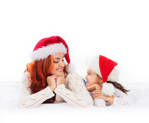 Mutlu bir anne ve bir kızın rahatlatıcı kırmızı Noel şapka — Stok fotoğraf