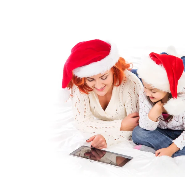 A happy mother and a daughter relaxing in red Christmas hats — Stock Photo, Image