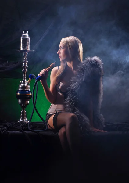 Une jeune femme blonde en lingerie sexy fumant un narguilé — Photo