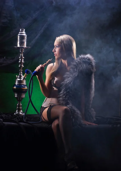 Una joven rubia en lencería sexy fumando una cachimba — Foto de Stock