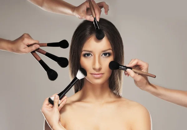 Studio photo of make-up process over grey background — Stock Photo, Image