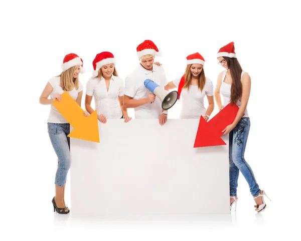 Een groep tieners in Kerstmis hoeden wijzen op een lege banne — Stockfoto