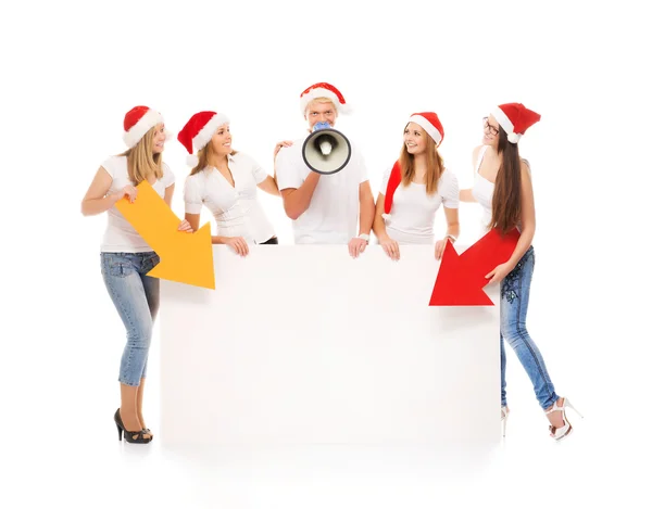 Un grupo de adolescentes con sombreros de Navidad señalando un banne en blanco — Foto de Stock