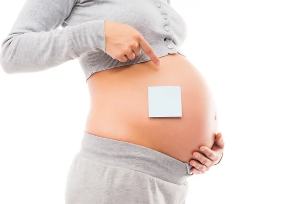 Belly of a young pregnant woman with a white sticker — Stock Photo, Image