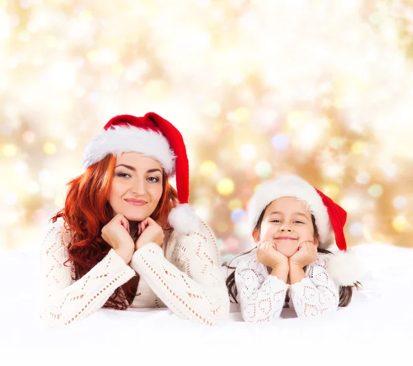 A young and happy mother and daughter over the Christmas backgro — Stock Photo, Image