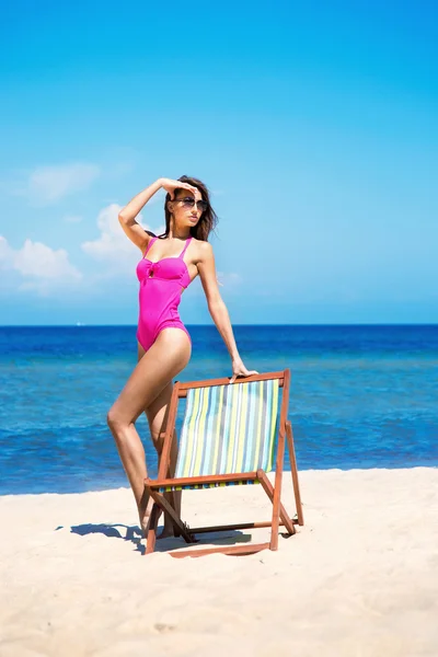 Een vrouw in een zwembroek op een zee resort achtergrond — Stockfoto