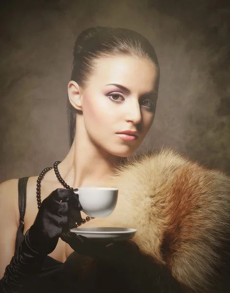 Portrait of a young woman in fur drinking coffee — Stock Photo, Image